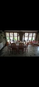comedor con mesa, sillas y ventanas en Hotel Riva, en Resen