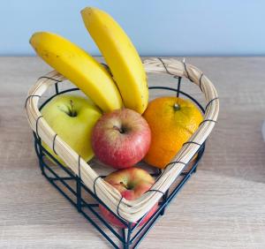 einen Obstkorb mit Äpfeln Orangen und Bananen in der Unterkunft Villa Residencial El Guaidil in Triquivijate