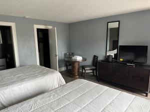a bedroom with two beds and a flat screen tv at Courtland Inn in Courtland