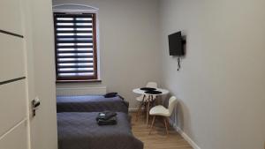 a room with two beds and a table and a window at Central Platinum Apartments in Rybnik