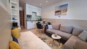 ein Wohnzimmer mit einem Sofa und einer Küche in der Unterkunft APARTAMENT RELAX BLUE MARE in Łukęcin