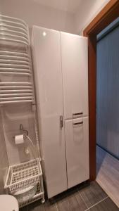 a white refrigerator in a bathroom with a toilet at APARTAMENT RELAX BLUE MARE in Łukęcin