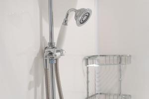 a shower with a shower head in a bathroom at Beautiful 3BR Home Close to Town Centre in Kent