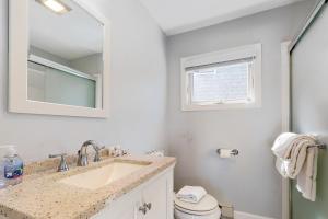 a bathroom with a sink and a toilet and a mirror at Beach Pleasure in Hampton