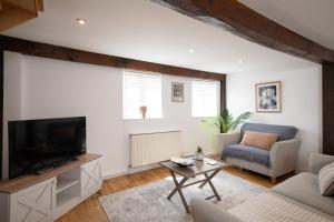 - un salon avec une télévision, un canapé et une table dans l'établissement Beautiful 3BR Home Close to Town Centre, à Kent