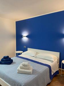 een blauwe slaapkamer met een bed met handdoeken erop bij Nice and cozy apartment in Àrbatax