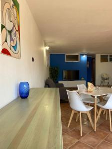 een woonkamer met een tafel en witte stoelen bij Nice and cozy apartment in Àrbatax