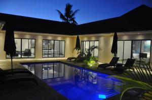 a house with a swimming pool at night at Grand Amber Villa in Diani Beach