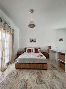 a white bedroom with a bed and a large window at ALAMENA II in Skiros