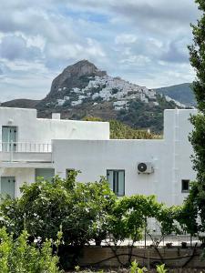 une maison blanche avec une montagne en arrière-plan dans l'établissement ALAMENA II, à Skiros