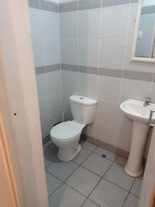 y baño con aseo y lavamanos. en HOSTAL PARIS en Piura