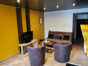 ein Wohnzimmer mit Sofa und Fernseher in der Unterkunft Love-room l'eden du Désir in Vecqueville