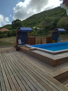 una terraza con piscina y bañera de hidromasaje en Aichi lodges gîtes en Capesterre