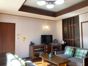 een woonkamer met een bank en een tv bij Minpaku Yagi - Vacation STAY 14700 in Ise
