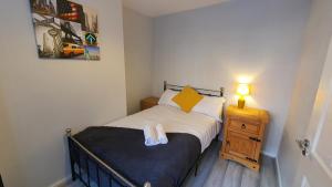 - une petite chambre avec un lit et une table de nuit dans l'établissement Contractors, City Centre, Parking, 3 Double Rooms, Netflix, Cosy!, à Coventry