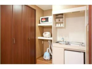 cocina con fregadero y armario de madera en Hotel Hanabi - Vacation STAY 67139v, en Tokio
