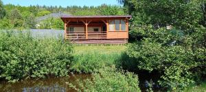 a wooden cabin on the side of a river at Domek nad Stawami - Warmia in Jonkowo