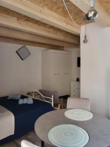 ein Schlafzimmer mit einem Bett und einem Tisch in einem Zimmer in der Unterkunft Pjaceta in Cres