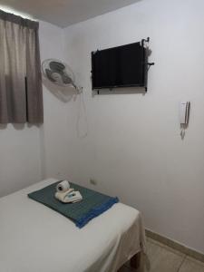 a room with a bed and a flat screen tv at HOSTAL PARIS in Piura