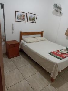 - une chambre avec un lit, une table de chevet et une sidx dans l'établissement HOSTAL PARIS, à Piura