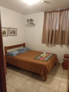 a bedroom with a bed with a fan and a window at HOSTAL PARIS in Piura