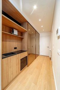 an empty room with a kitchen with wooden cabinets at Kennedy Residence Belgrade in Belgrade