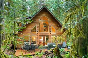 a log cabin in the woods with a patio at Fern Hollow in Glacier