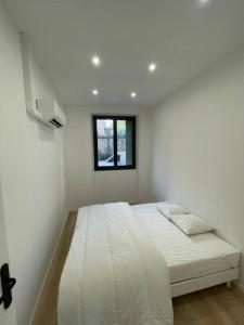 a white bedroom with a bed with a window at Charmant appart / 4 pers /2 ch /centre/Vieux-Port in Marseille