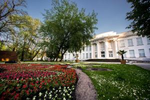 a garden of flowers in front of a white building at Solankowe Zacisze De Lux Inowrocław in Inowrocław
