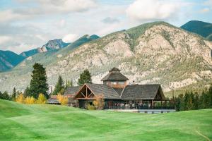 a large building in front of a mountain at Headwaters Lodge at Eagle Ranch Resort in Invermere