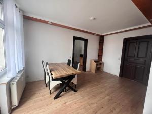ゲーラにあるGera Apartmentの木製のテーブルと椅子、ドアが備わる客室です。