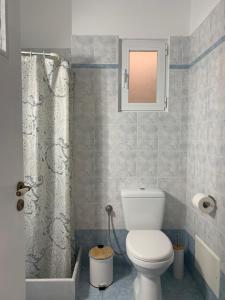 a bathroom with a toilet and a shower curtain at Fabrika Apartments in Vari