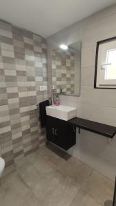 uma casa de banho com um lavatório e um espelho em CASA INDEPENDIENTE SUANCES - 800m2 de jardín - Parking - Wifi5G em Cortiguera