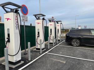 una fila de coches eléctricos estacionados en un estacionamiento en Holiday Inn Dijon Sud - Longvic, an IHG Hotel en Dijon