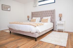 a bedroom with a large bed and a wooden floor at Pata da Gaivota Boutique House in Lourinhã