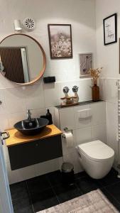 een badkamer met een wastafel, een toilet en een spiegel bij BOSTEL 88 - Moderne Stadtwohnung mit Klimaanlage in Moers