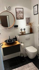 a bathroom with a sink and a toilet and a mirror at BOSTEL 88 - Moderne Stadtwohnung mit Klimaanlage in Moers