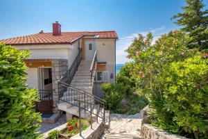 een huis met een trap naar de oceaan bij Apartments More in Klenovica