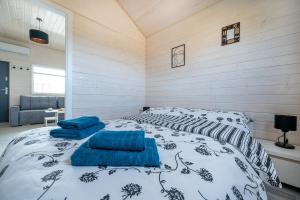 a bedroom with a bed with blue pillows on it at Domki Hulaj Dusza in Bobolin +39 photos