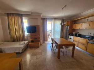 a room with a bed and a table and a kitchen at Alanya gold city villa in Alanya