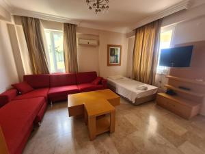 a living room with a red couch and a table at Alanya gold city villa in Alanya