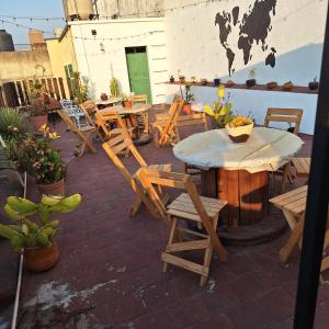 een patio met houten tafels en stoelen en een tafel en stoelen bij Hostal Guadalajara in Guadalajara