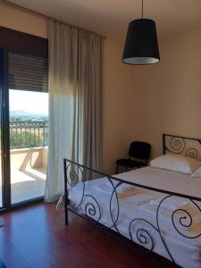 a bedroom with a bed and a view of a balcony at Villa Panoramica in Pylíon