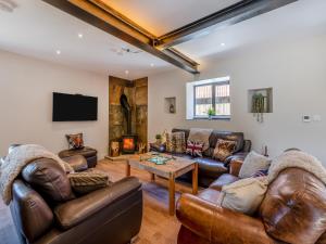 a living room with leather furniture and a flat screen tv at The Warren - Uk42858 in Rise