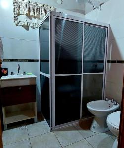 y baño con ducha, aseo y lavamanos. en Cabaña Jano en Posadas