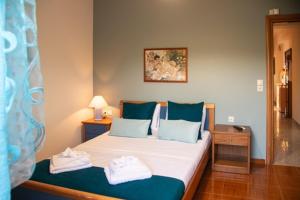 a bedroom with a bed with blue and white pillows at Villa sotiris in Kissamos
