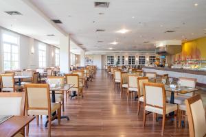 un restaurante con mesas y sillas y un bar en Saui­pe Premium Sol All Inclusive en Costa do Sauipe