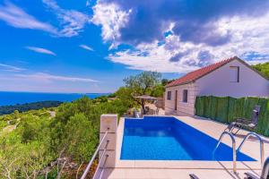 a house with a swimming pool with a view of the ocean at Vila Podkalac in Žrnovo