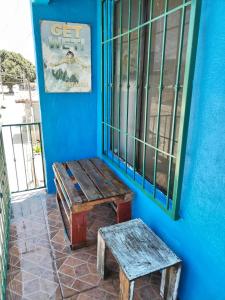 a wooden bench and a stool next to a blue wall at Monchita's Ensenada Baja, apartments for rent. in Ensenada