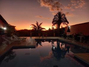 una piscina con tramonto sullo sfondo di Pousada Estância Tertúlia a São Tiago
